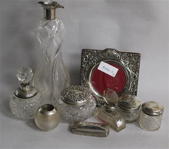 An Edwardian silver collared glass decanter by Elkington & Co and eight other items including toilet jars and match strike.